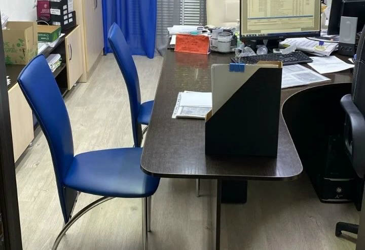 Место приема в нотариальной конторе: стол и два стула для посетителей